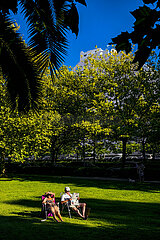 FRANCE. HERAULT (34) LA GRANDE-MOTTE. A RETIRED COUPLE SITTING IN CHAIRS ON THE LAWN OF A GREEN SPACE