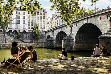 FRANCE. PARIS (75) 4TH DISTRICT. PARIS PLAGES 2023. PEOPLE SITTING ON THE QUAY DE SEINE AT THE PONT MARIE BRIDGE