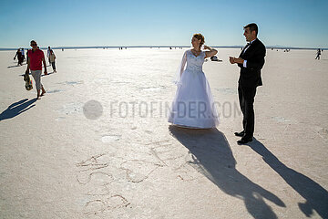 Tuerkei  Sereflikochisar - Hochzeitspaar  rocken gefallener Teil des Salzsees Tuz Goelue  einer der salzhaltigsten Seen der Welt