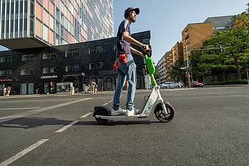 Deutschland  Berlin - Junger Mann auf e-scooter im Stadtteil Kreuzberg