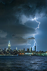 UNITED STATES  NEW YORK CITY  MANHATTAN  MIDTOWN. LIGHTNING STRIKING NEW YORK CITY SKYSCRAPERS (EMPIRE STATE BUILDING) AT NIGHT. STORMY SKIES OVER MIDTOWN MANHATTAN FROM THE HUDSON RIVER