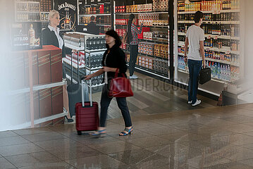 Polen  Warschau - Polen  Warschau - Frau passiert Werbung fuer Duty-Free-Shop am Chopin-Flughafen