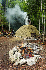 FRANCE. ISERE (38) VERCORS NATURAL PARK. PREPARATION AND LIGHTING OF A CHARCOAL FIRE BY THE ATRA'VERCORS ASSOCIATION