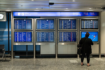 Frankfurt  Deutschland  Flugreisende schaut auf Anzeigetafel mit Fluginformationen fuer Abfluege im Terminal 1 am Frankfurter Flughafen
