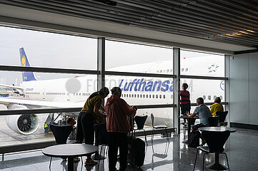 Frankfurt  Deutschland  Fluggaeste im Abflugbereich mit Passagierflugzeug der Lufthansa am Gate des Terminal 1 auf dem Frankfurter Flughafen
