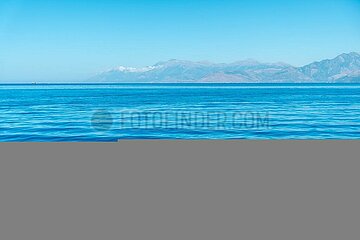 Turquoise sea water texture with sun rays in the mediterranean sea and sky background