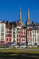 FRANCE. PYRENEES-ATLANTIQUES (64). BAYONNE. ROW OF HOUSES ON QUAI A. JAUREGUIBERRY (QUAYS OF THE NIVE). IN THE BACKGROUND: THE SPIERS OF SAINTE-MARIE CATHEDRAL