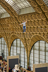 FRANCE. PARIS (75) (7TH DISTRICT) ORSAY MUSEUM: TIGHTROPE WALKER NATHAN PAULIN CROSSES THE NAVE OF THE MUSEUM (AS PART OF EUROPEAN HERITAGE DAYS). THIS PERFORMANCE  ?LES TRACEURS?  WAS DESIGNED BY CHOREOGRAPHER RACHID OURAMDANE. IN ADDITION TO N.PAULIN'S STROLL ABOVE THE VISITORS  THE PERFORMANCE COMBINES THE SPECTACLE OF 9 ACROBATS ON THE GROUND. (2023/09/16)