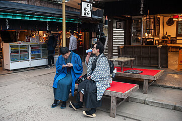 Kyoto  Japan  Junge Japaner in traditioneller Kleidung pausieren auf dem Pilgerweg zum Mt. Inari