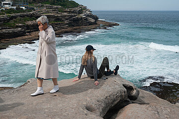 Sydney  Australien  Eine junge und eine aeltere Frau auf den Klippen am Tamarama Point