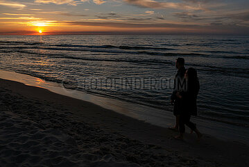 Polen  Kolobrzeg - Paar bei Sonnenuntergang an der Ostsee