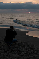Polen  Kolobrzeg - Hobbyfotograf fotografiert den Sonnenuntergang am Ostseestrand