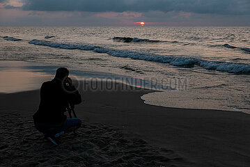 Polen  Kolobrzeg - Hobbyfotograf fotografiert den Sonnenuntergang am Ostseestrand