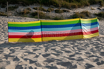 Polen  Dzwirzyno - Sillhouette eines Urlaubers hinter einem Windschutz am Strand