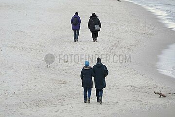 Paare gehen am Strand spazieren