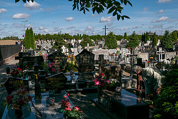 Polen  Opatowko - katholischer Friedhof auf dem Land  Witwe bei der Grabpflege