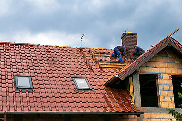 Polen  Szewce - Dachdecker auf dem Dach eines Neubaus fuer ein Einfamilienhaus