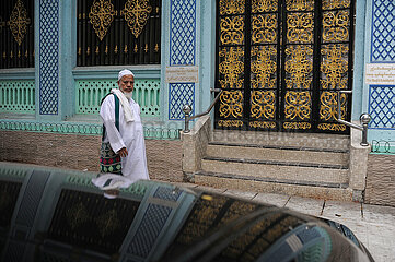 Yangon  Myanmar  Ein glaeubiger Muslim geht an einer Moschee im Stadtzentrum vorbei