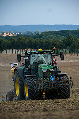 Deutschland  Kluetz - Landwirt beim Pfluegen mit dem Traktor in der Daemmerung