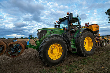 Deutschland  Kluetz - Landwirt beim Pfluegen mit dem Traktor in der Daemmerung