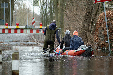 Deutschland  Bremen - ueberschwemmte Strasse  Hochwasser an der Wuemme  Feuerwehrmann bringt Anwohner mit Schlauchboot zu ihrem Haus