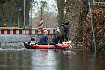 Deutschland  Bremen - ueberschwemmte Strasse  Hochwasser an der Wuemme  Feuerwehrmann bringt Anwohner mit Schlauchboot zu ihrem Haus