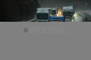 Deutschland  Bremen - LKWs auf nasser Autobahn in der Abenddaemmerung