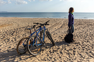 Frau mit mountainbike am Strand