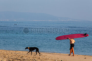 Surfer mit Surfbrett am Strand