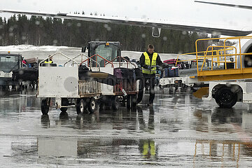 Evenes  Norwegen  Flughafenmitarbeiter verlaedt auf dem Vorfeld des Flughafen Harstad/Narvik Koffer in ein Flugzeug