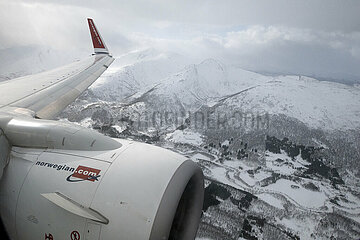 Evenes  Norwegen  Triebwerk und Tragflaeche eines Flugzeugs der Norwegian Airlines ueber der verschneiten Landschaft
