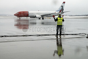 Evenes  Norwegen  Boden-Lotse nimmt ein Flugzeug der Norwegian Airlines auf dem Vorfeld des Flughafen Harstad/Narvik in Empfang