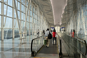 Hong Kong  China  Reisende stehen im Terminal des Hong Kong International Airport auf einem Laufband