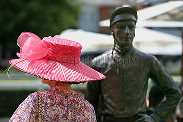 Royal Ascot  Fashion: Woman with hat and the statue of jockey Lester Piggott