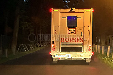 Hoppegarten  Deutschland  Pferdetransporter faehrt bei Nacht eine Strasse entlang