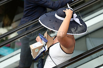 Royal Ascot  Fashion: Woman with hat on an escalator inside the grandstand