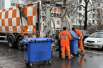 Berlin  Deutschland  Mitarbeiter der Stadtreinigung entlerren volle Papiertonnen in einen Muellwagen