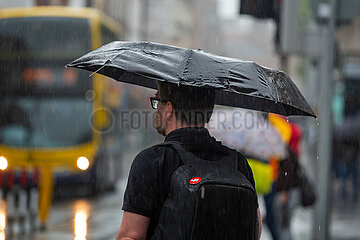 Republik Irland  Dublin - Mann mit Regenschrim  regnerischer Tag in der Stadt (Stadtzentrum)