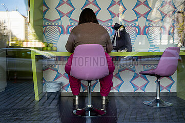 Berlin  Deutschland  Frau sitzt im Hotel nhow Berlin auf einem Drehstuhl an einem Schreibtisch
