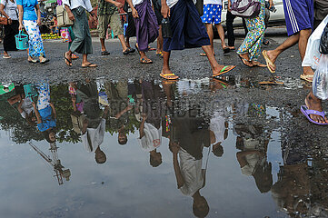 Yangon  Myanmar  Menschen spiegeln sich in einer riesigen Pfuetze waehrend der Regenzeit