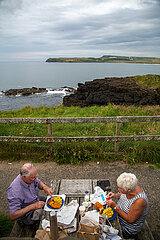 Grossbritannien  Nordirland  Portballintrae  County Antrim - Glueckliches Rentnerpaar bei Fish and chips mit Blick auf die Irische See