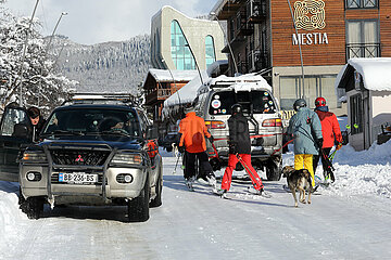 Mestia  Georgien  Skifahrer lassen sich von einem Auto durch die Stadt ziehen