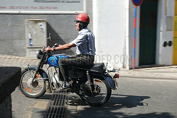 Monchique  Portugal  Mann faehrt auf seinem Motorrad durch die Stadt