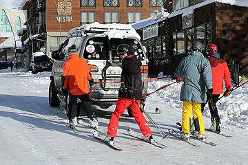 Mestia  Georgien  Skifahrer lassen sich von einem Auto durch die Stadt ziehen