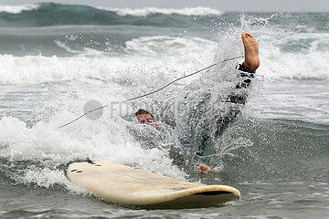 Sagres  Portugal  Teenager ist beim Surfen von seinem Surfbrett ins Wasser gefallen