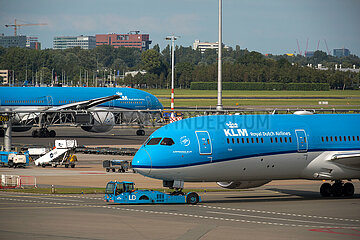 Niederlande  Amsterdam - gelandetes Flugzeug der KLM mit Flugzeugschlepper an ihrem Heimatflughafen Amsterdam Airport Schiphol (AMS)  hinten ein anderes vor dem Start