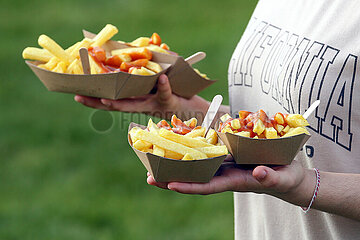 Hannover  Deutschland  vier Portionen Pommes Frites mit Ketchup in zwei Haenden