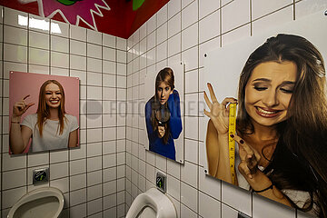 Deutschland  Muenster - Pissoir in einer Kneipe mit Fotos von Frauen  die auf die Groesse des Penis anspielen
