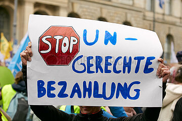 Berlin  Deutschland - Eine Demonstrantin haelt ein selbstgemaltes Schild mit der Aufschrift - STOP Ungerechte Bezahlung - bei der Demonstration zum Thema Hauptstadtzulage hoch.