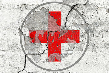 Rotes Kreuz auf rissiger Wand
